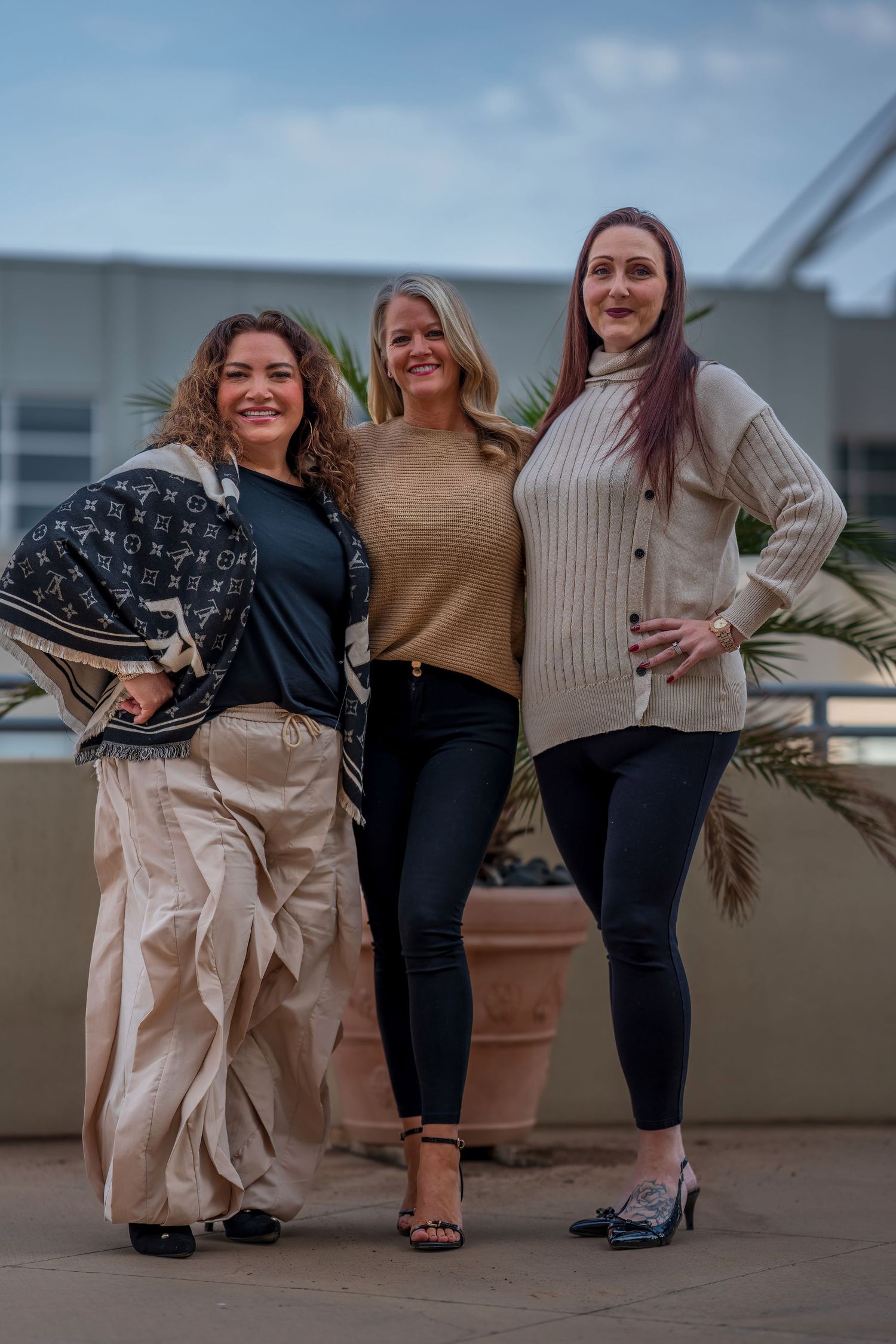 Casual group portrait on urban rooftop with decorative plants.