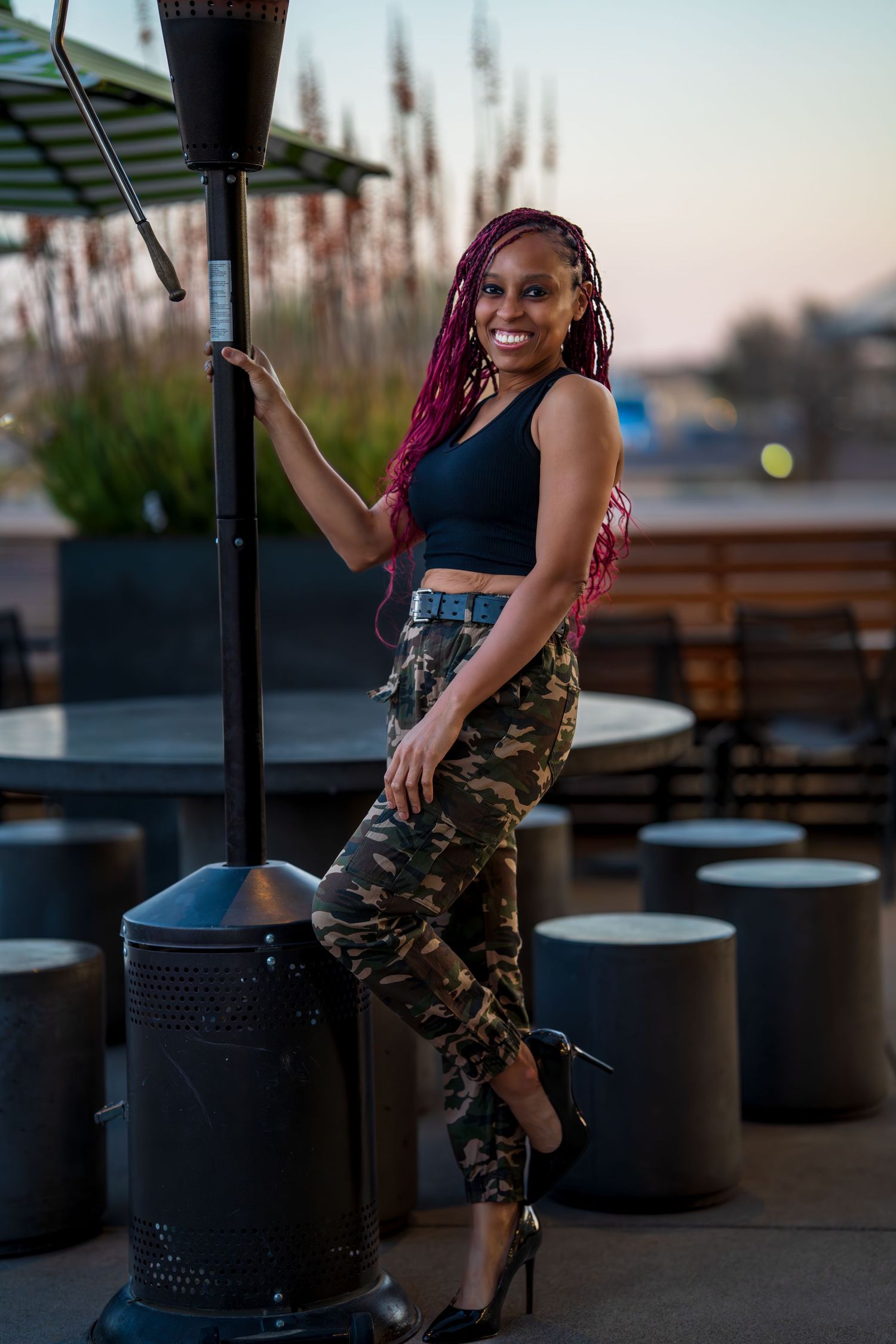 Evening photoshoot on an outdoor patio with decorative planters and seating.