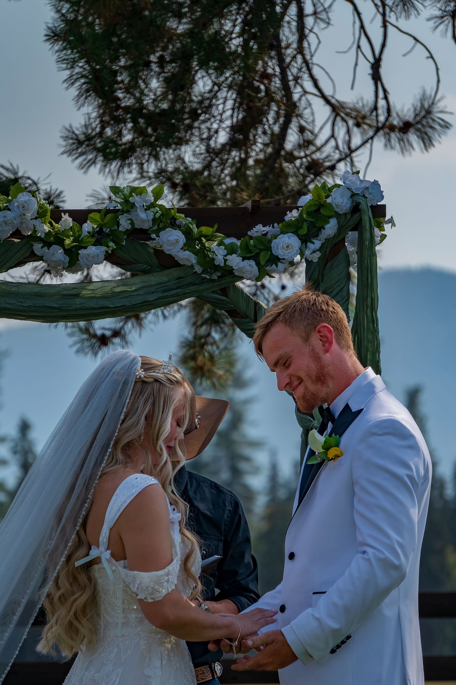 A couple exchanges rings during their outdoor mountain wedding ceremony.