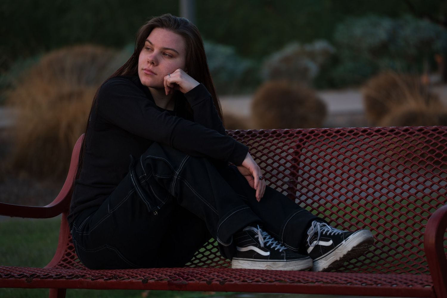 Person resting on outdoor patio furniture at dusk.