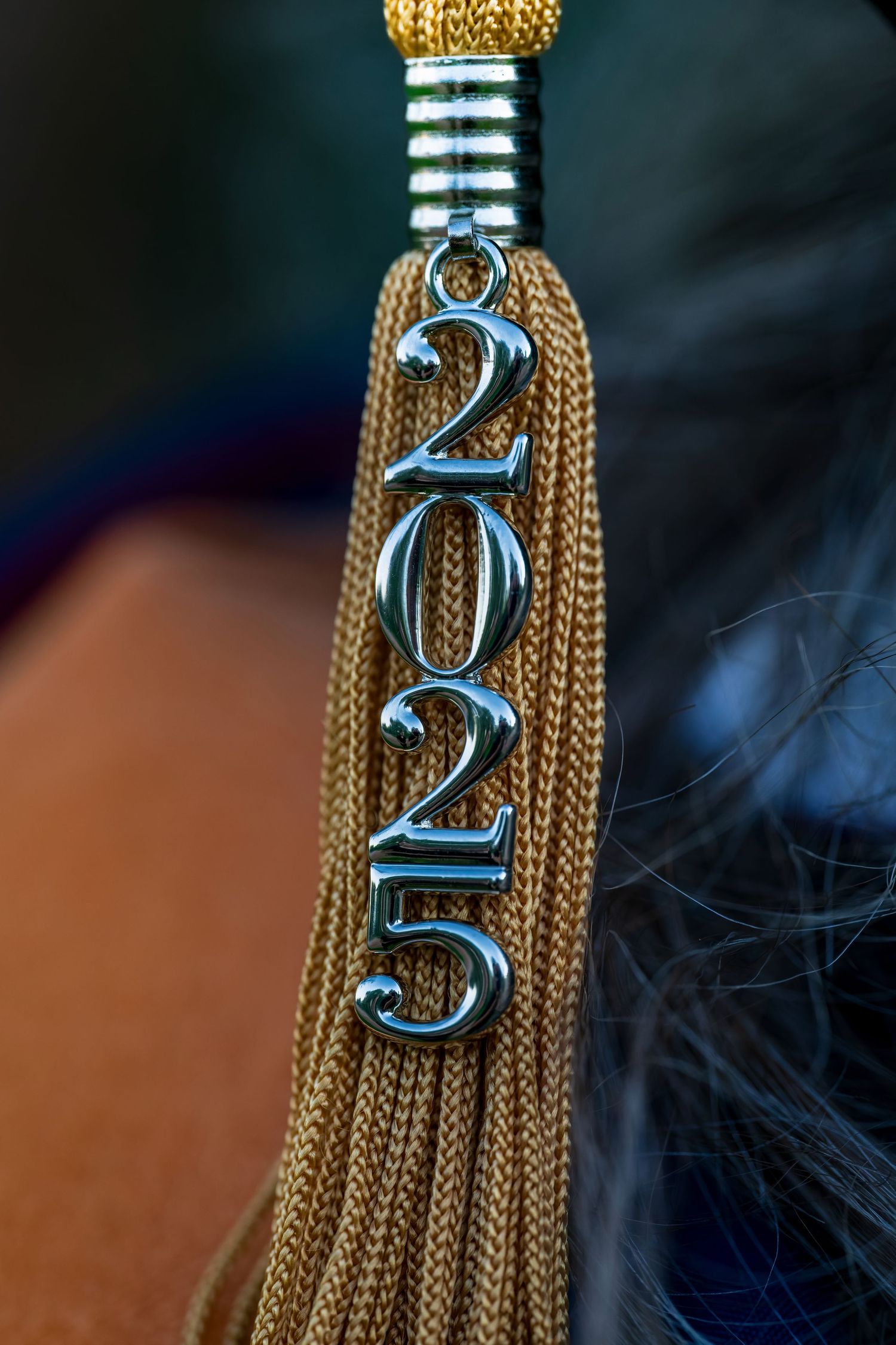 Detailed view of gold graduation tassel with 2022 year charm.