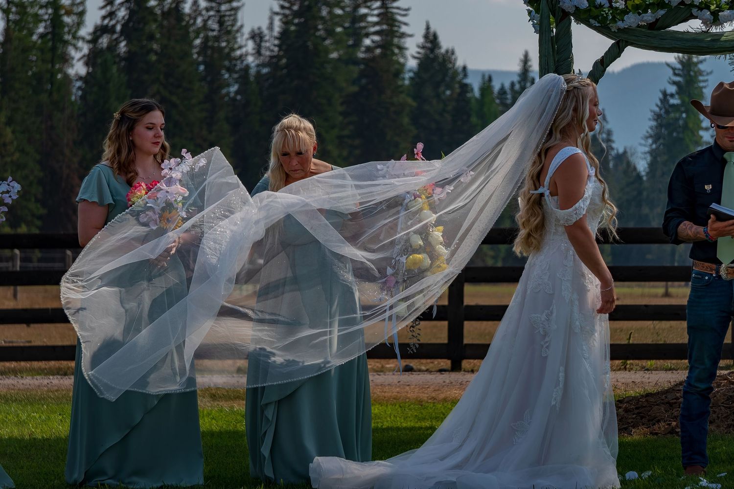A flowing white wedding veil catches the breeze during an outdoor ceremony.