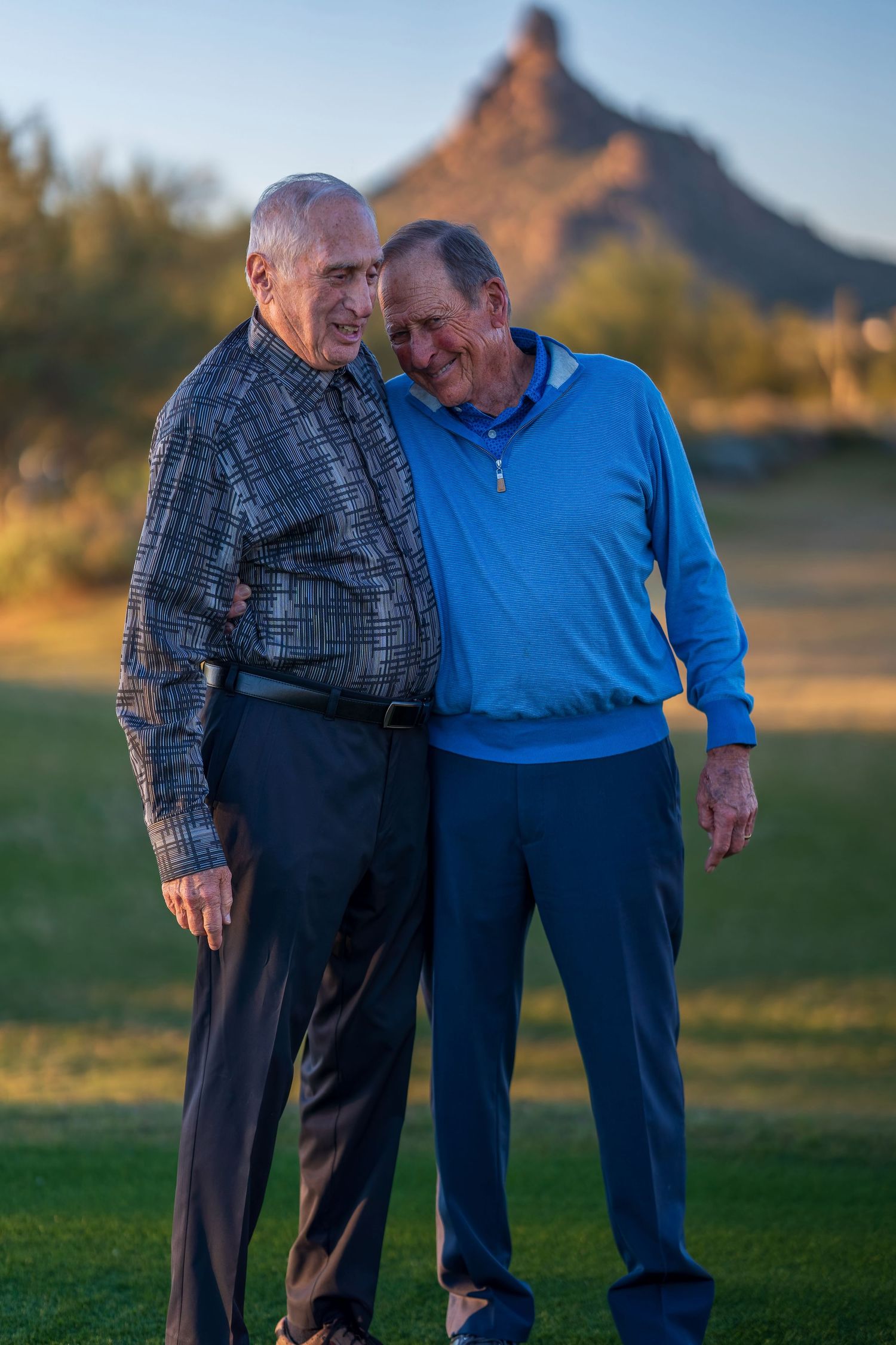 Candid moment between two people laughing together outdoors at sunset.