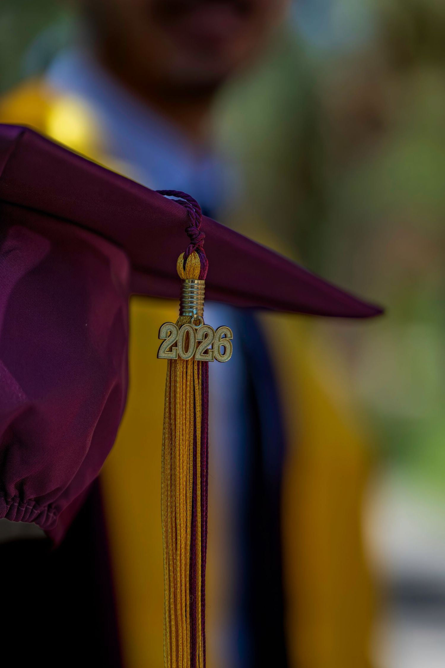 Close-up of a maroon graduation cap with a gold 2026 tassel charm at an Arizona State University ceremony.