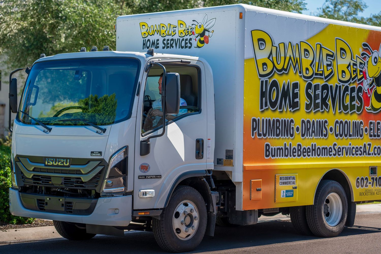 Line of Bumble Bee Plumbing service vans and trucks parked outdoors.