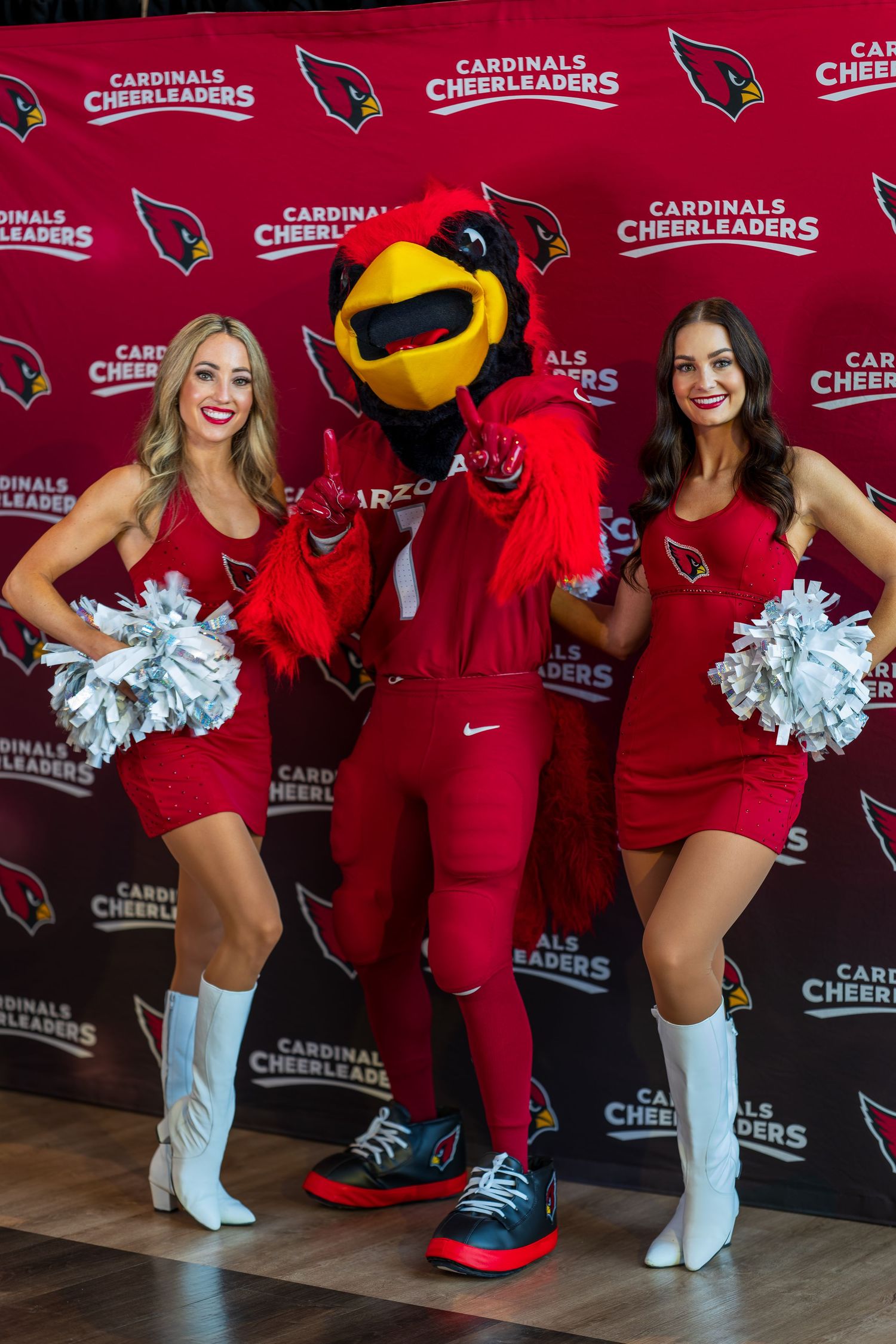 Cardinals mascot and cheerleaders posing together at team promotional event.