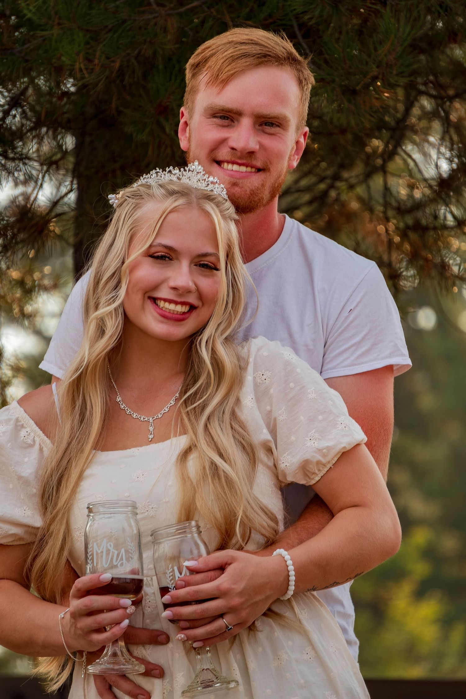 Happy couple sharing intimate moment while holding wine glasses outdoors.