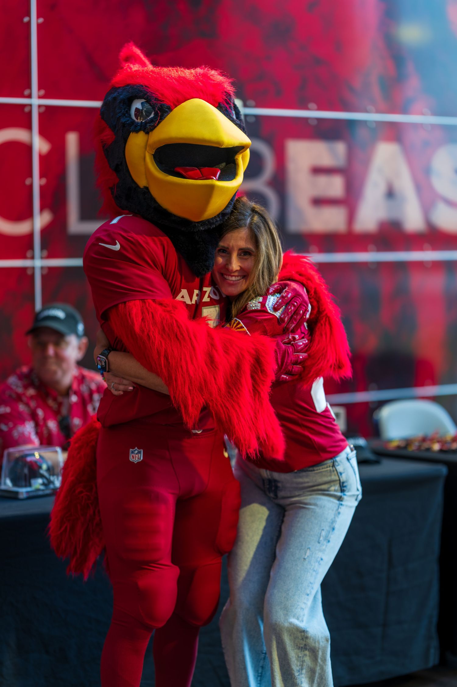 Cardinals mascot in red costume interacts with crowd at team event.