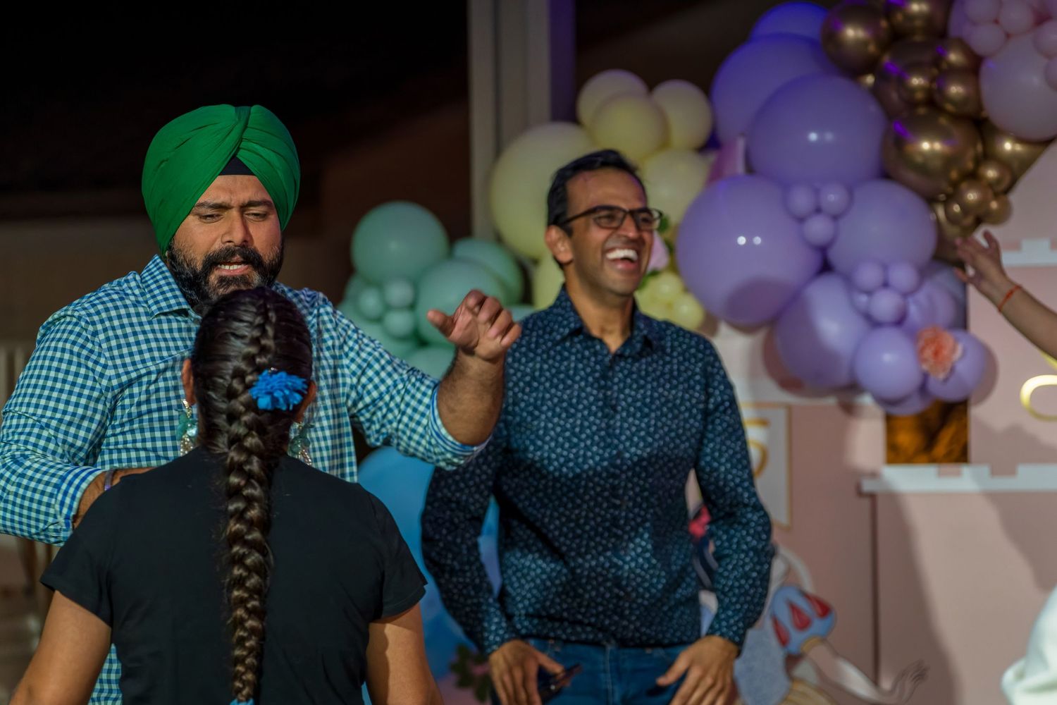 Guests enjoying themselves at a festive celebration with balloon decorations.