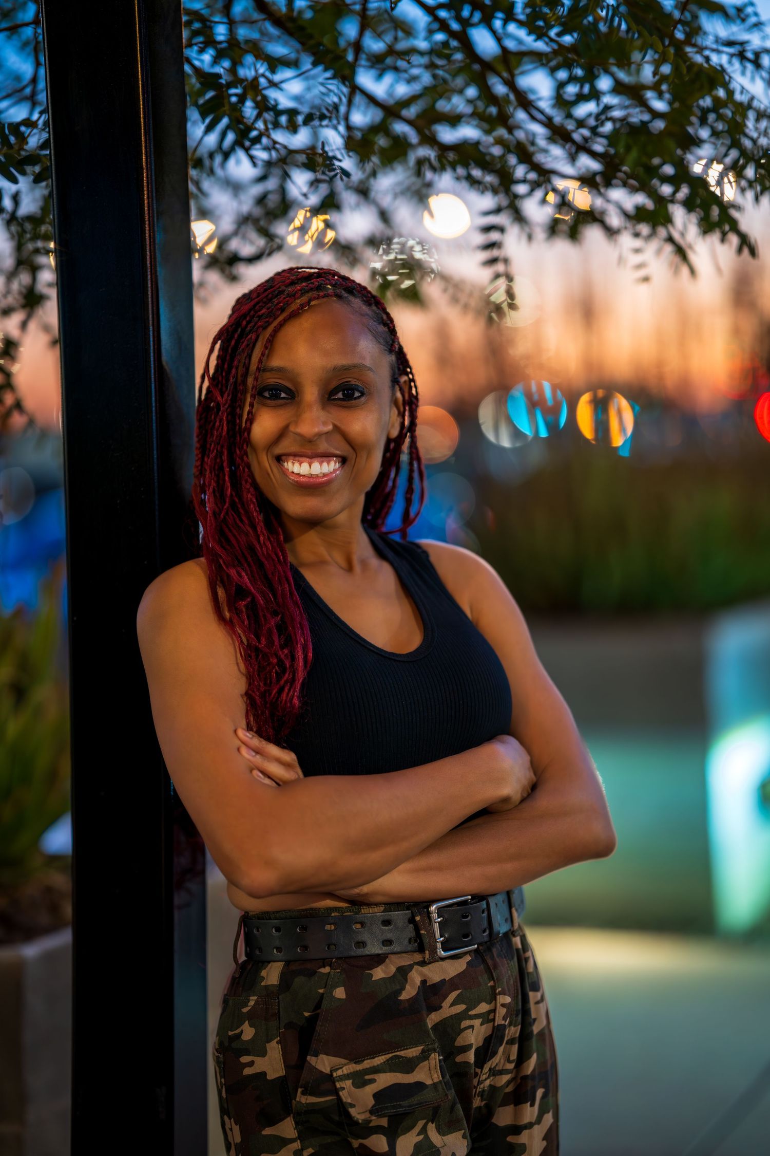 Casual outdoor portrait against sunset sky with decorative lighting.