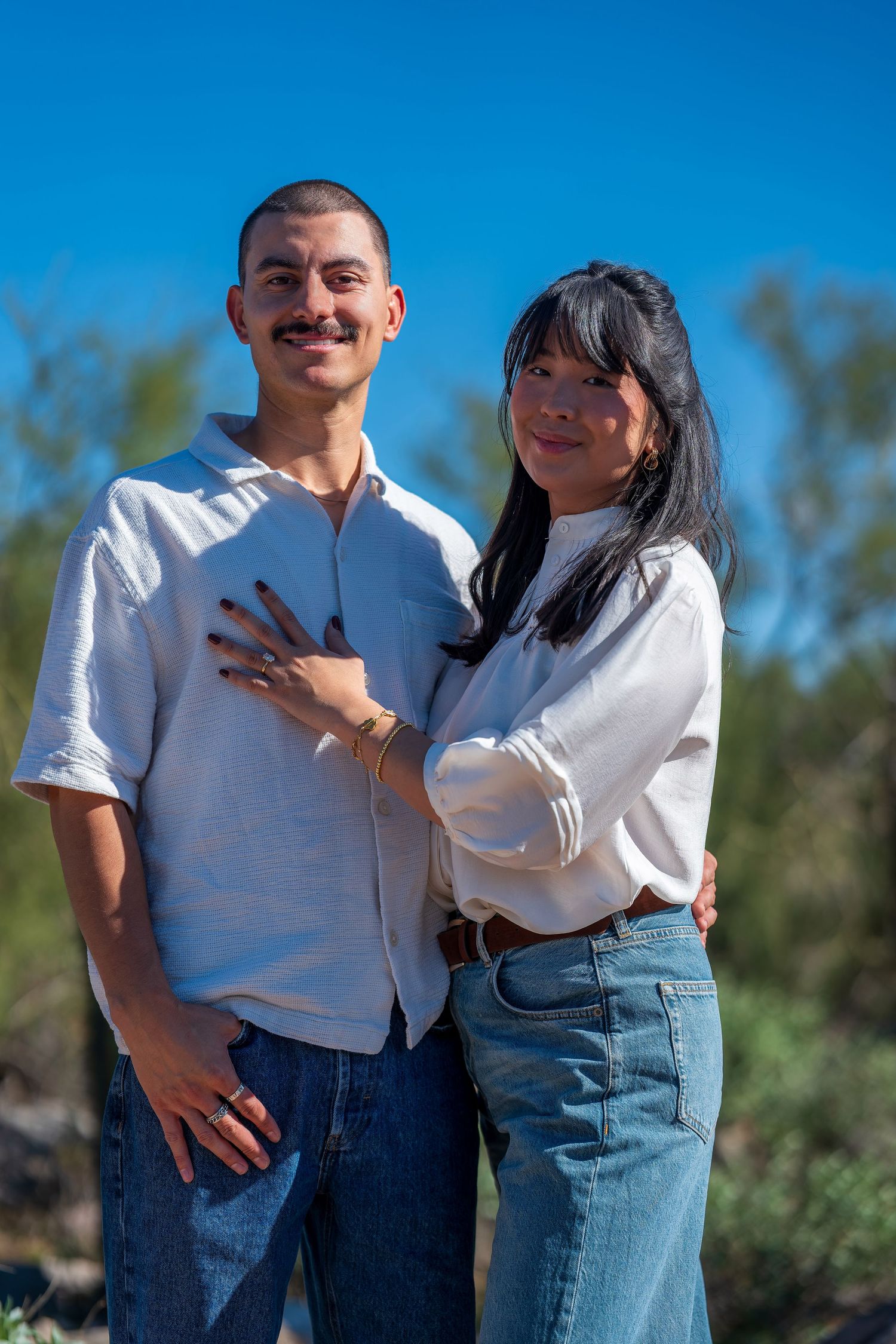 Casual outdoor portraits with desert landscape and saguaro cacti in the background.