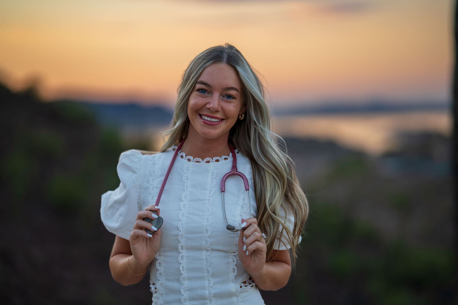 Sunset desert photoshoot with medical professional holding stethoscope.