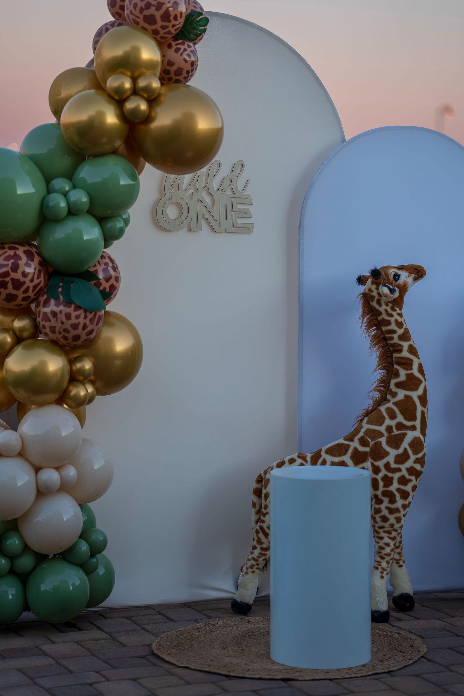 Safari-themed party setup with giraffe decorations and gold balloon arrangements.