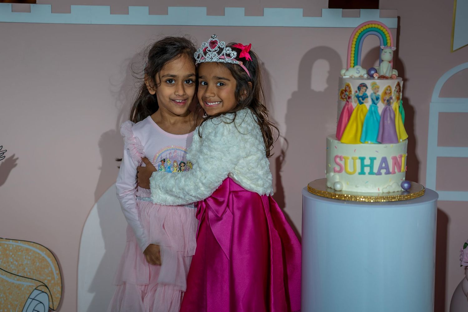A birthday party celebration with decorative balloons and a tiered cake in the background.