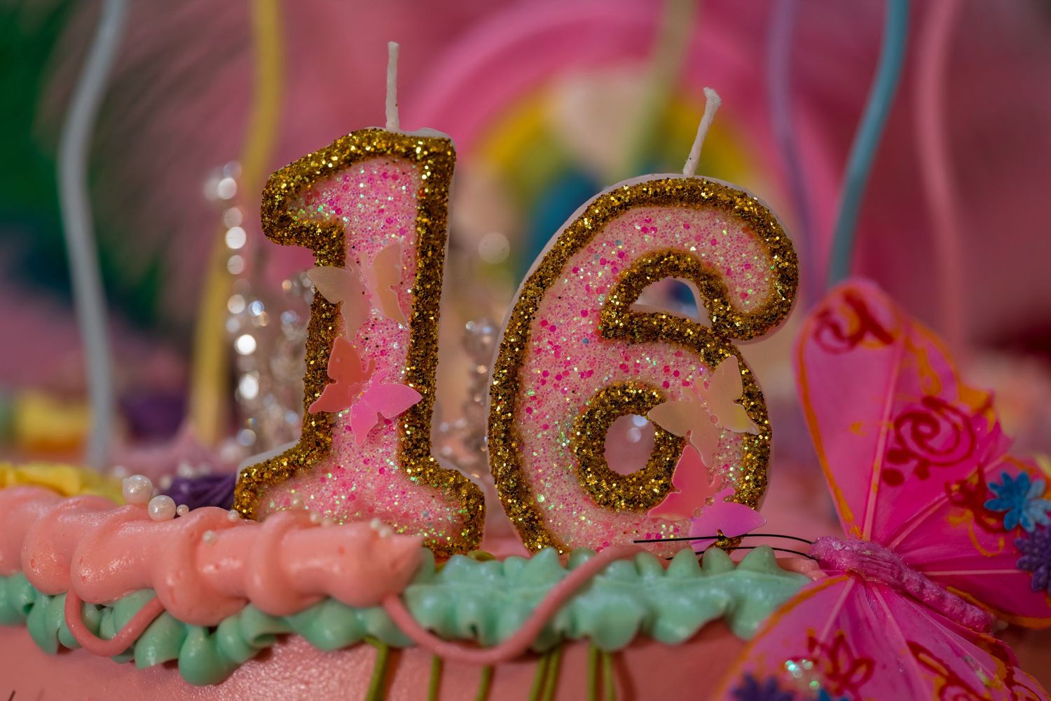 Close-up of glittery pink birthday decorations with mint green accents.