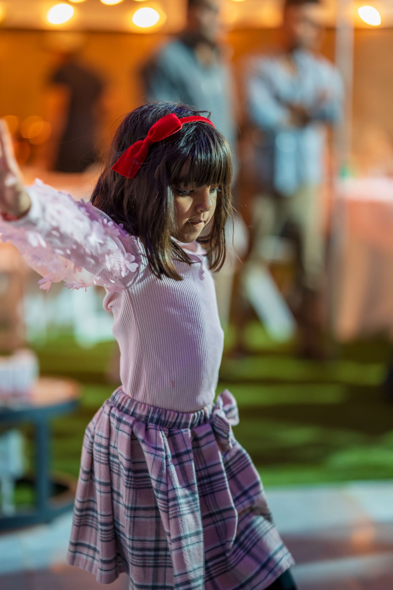 A sequence showing a plaid dress and pink ruffles during a dance performance.
