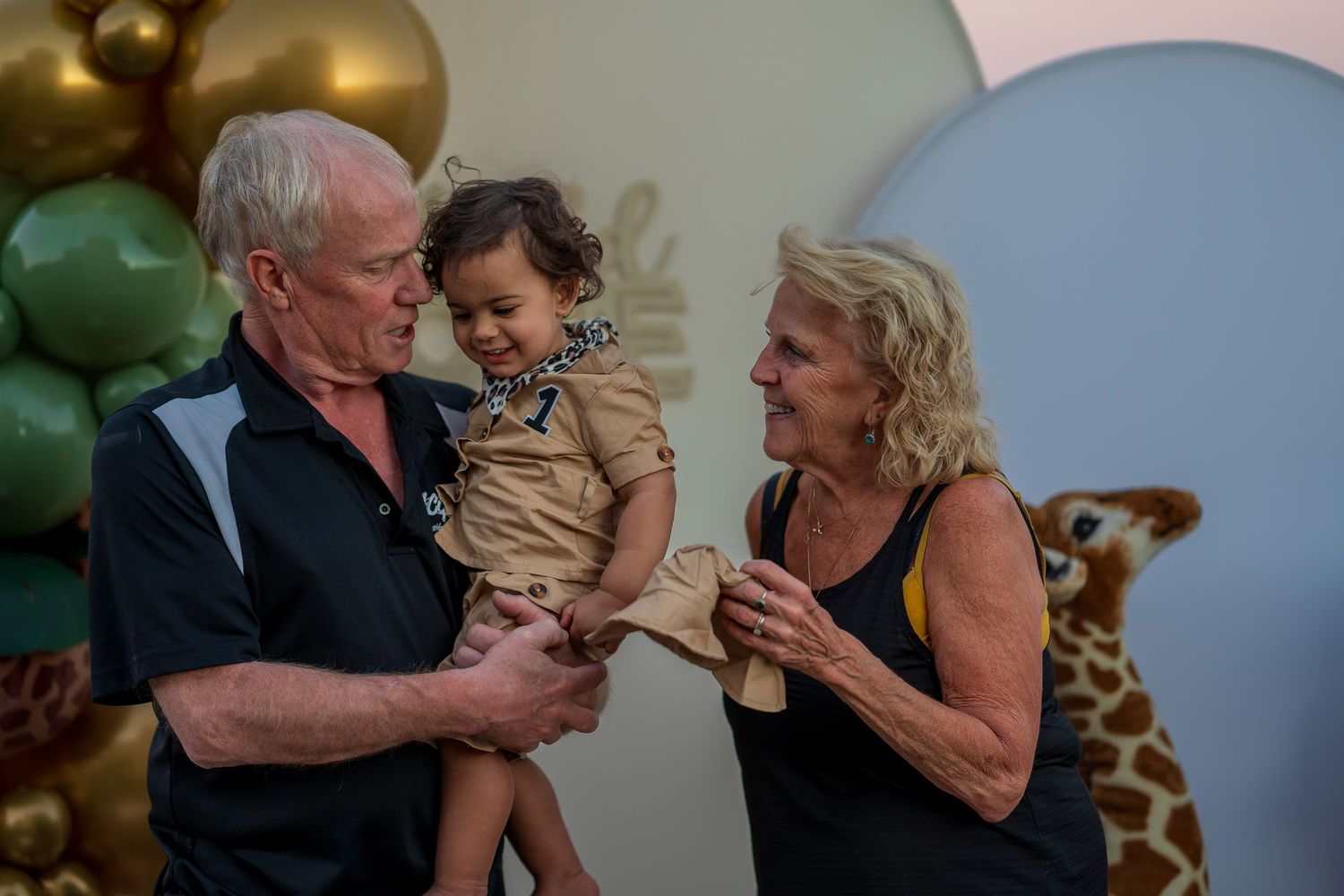 Family gathering at safari-themed birthday party with balloon decorations.