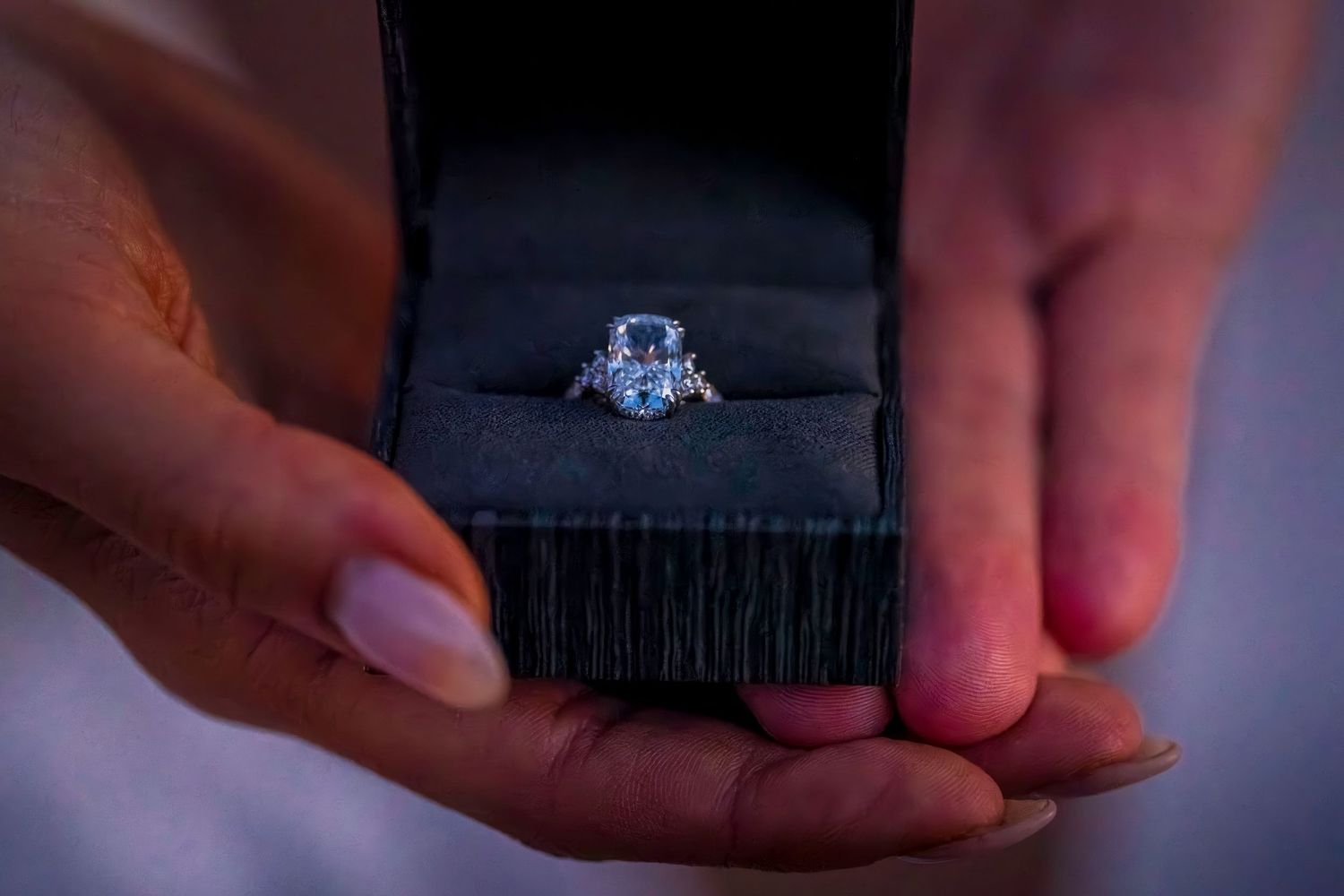 Close-up shots of hands holding small objects in dim lighting.