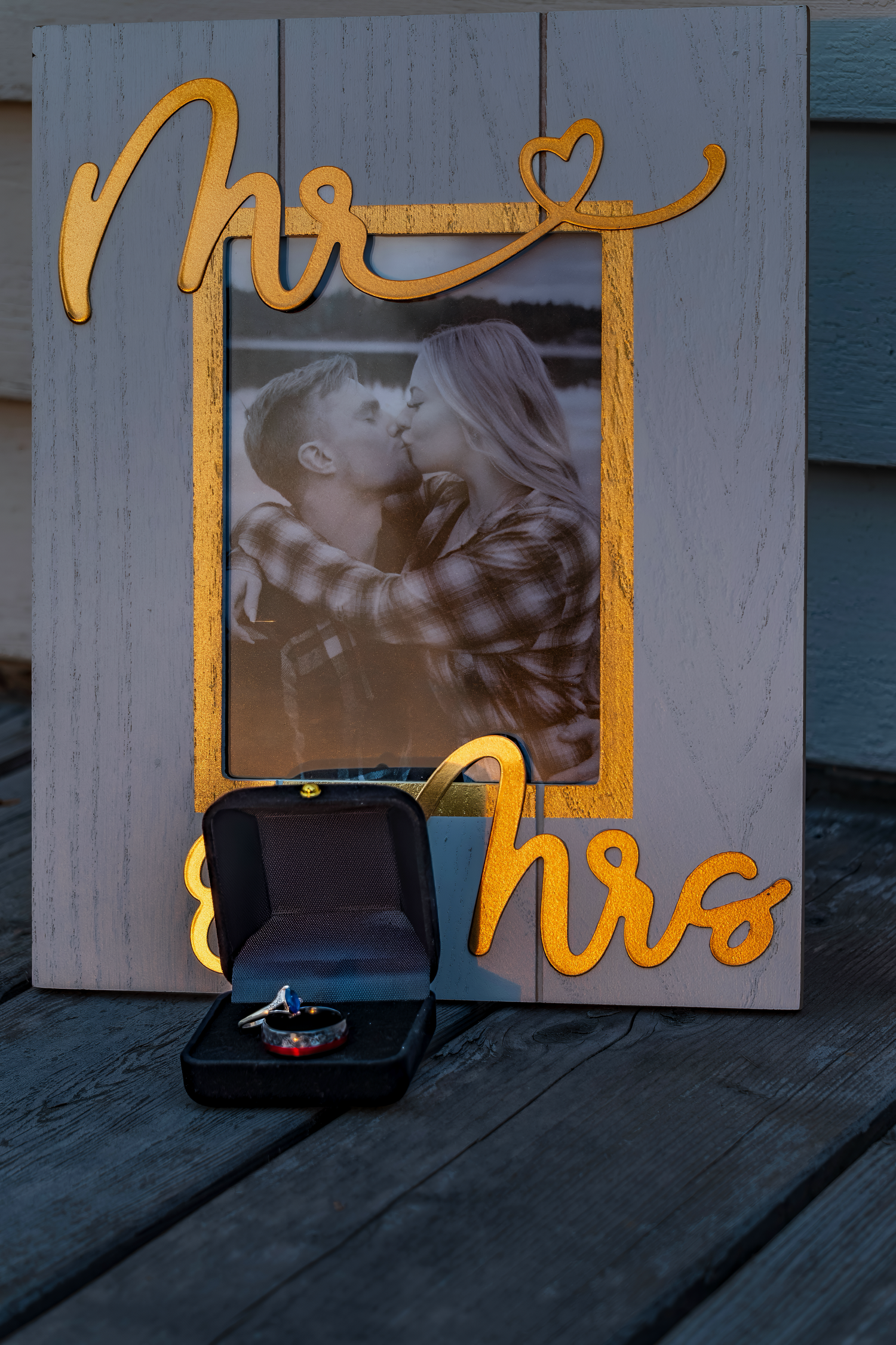 Wedding photo display with gold text and decorative elements on rustic wood background.