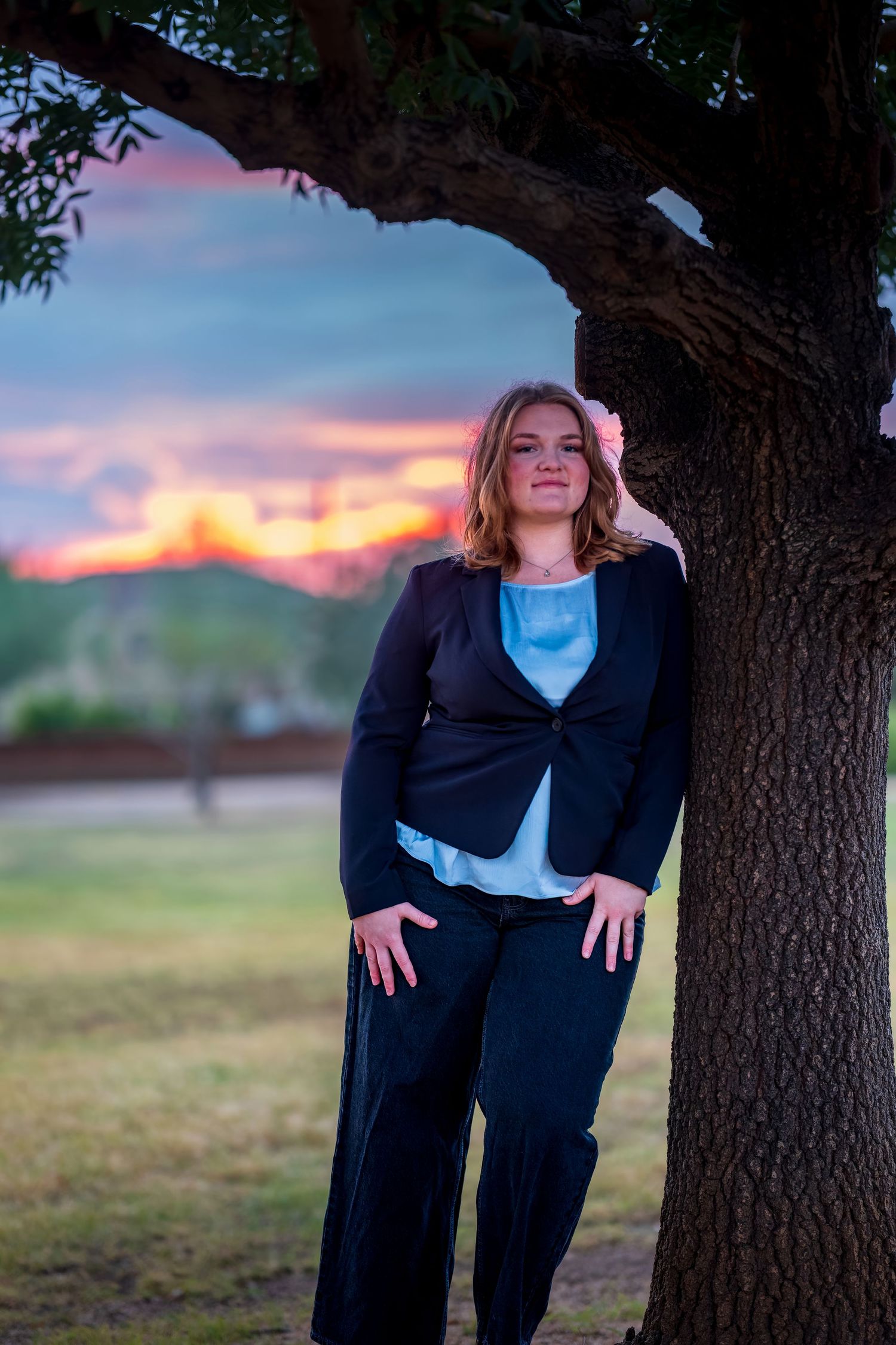 Sunset photoshoot under a large tree featuring professional business attire.