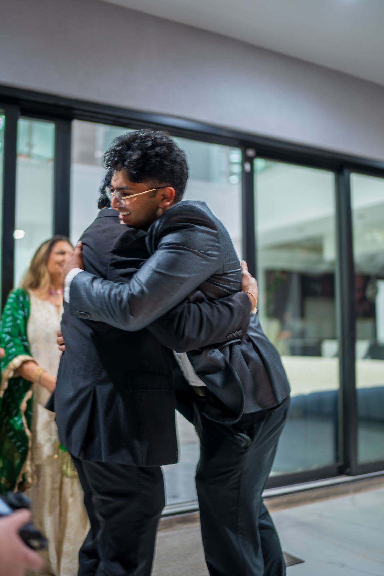 Two people share a warm embrace in formal attire during a special occasion.