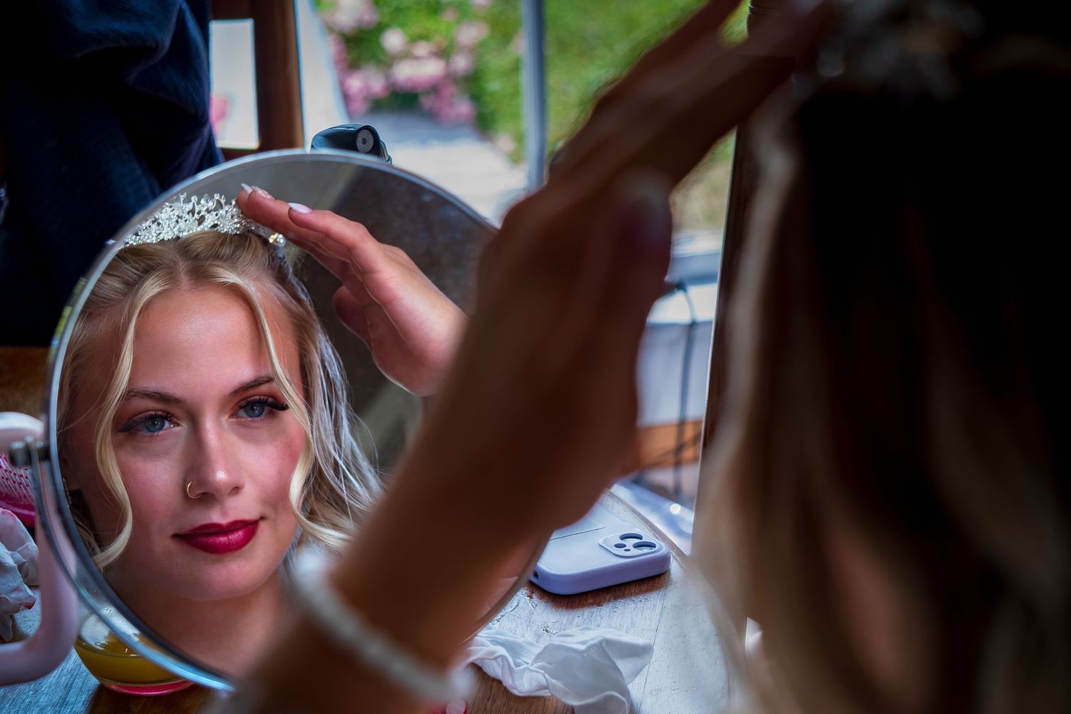 Wedding preparation photos showing final touches being made to the bride's hair and accessories.