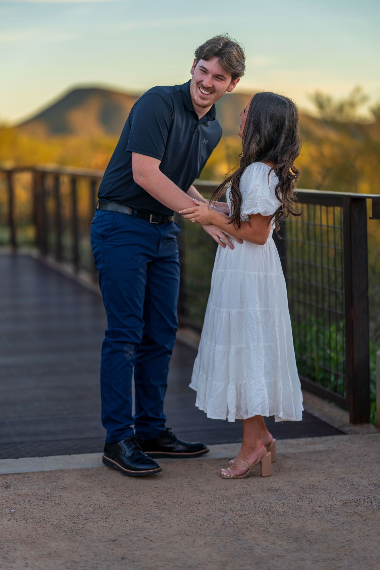 A special moment between two people on an outdoor observation deck with desert views.