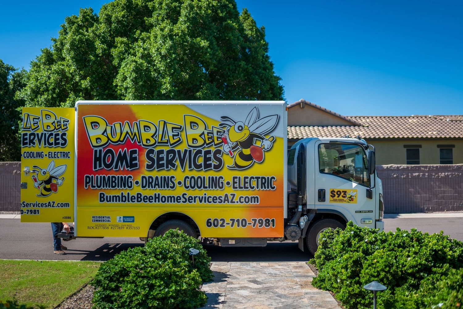 Bumble Bee Home Services branded vehicles parked outside residential building.