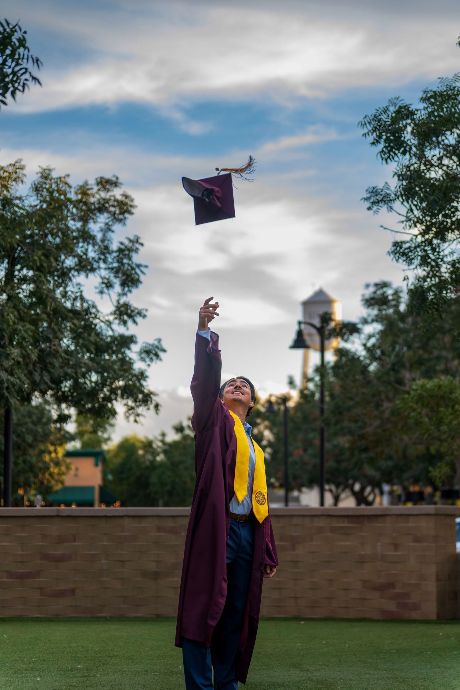 Maroon graduation cap flies through air during celebratory cap toss.