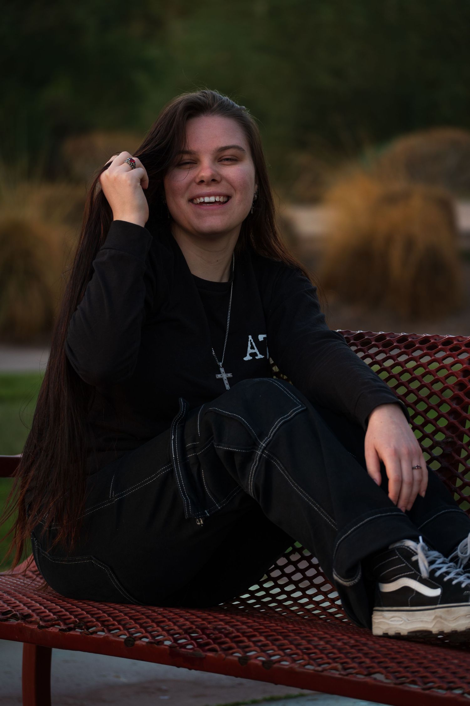 Candid moment captured on red bench showing joyful expression and casual style.