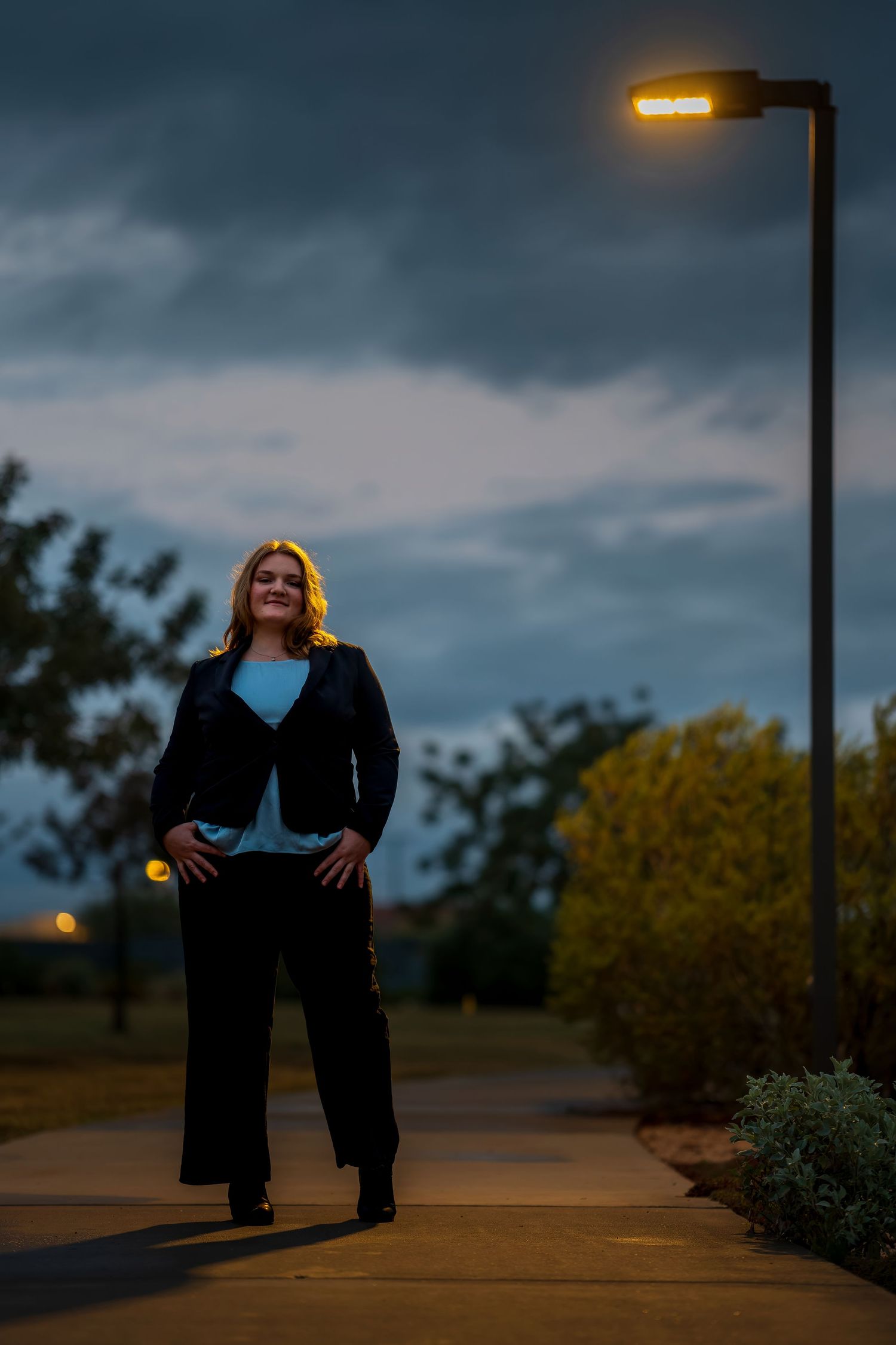 Dramatic night photography with street lamp illumination and cloudy sky.