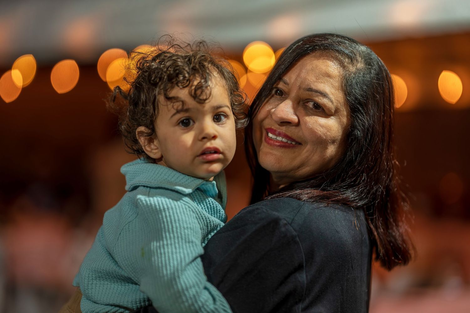 A joyful moment captured at a nighttime celebration with warm bokeh lighting.