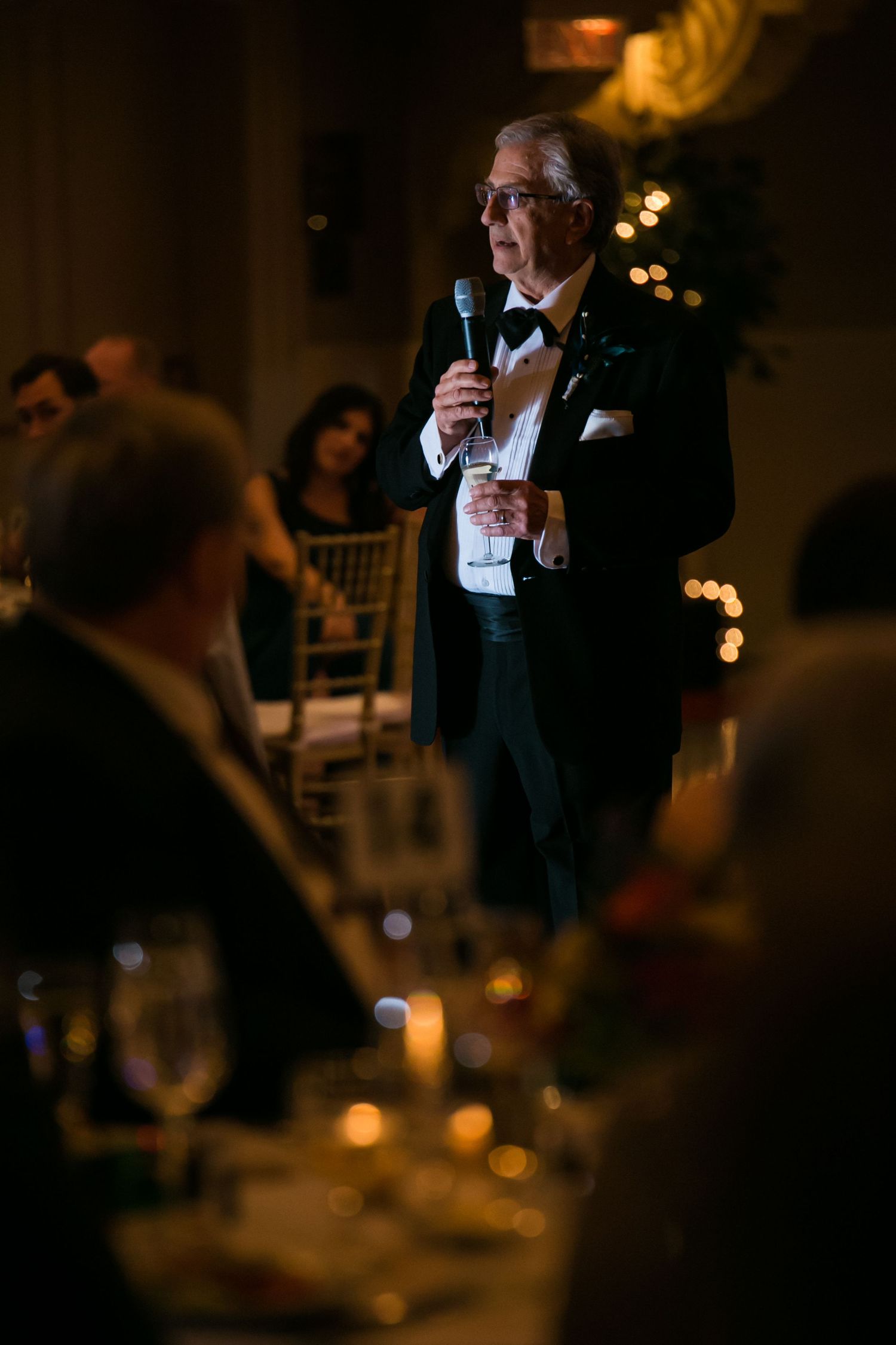 Father of the bride in tuxedo giving a wedding toast with microphone at the reception, Mechanics Hall, Worcester, MA