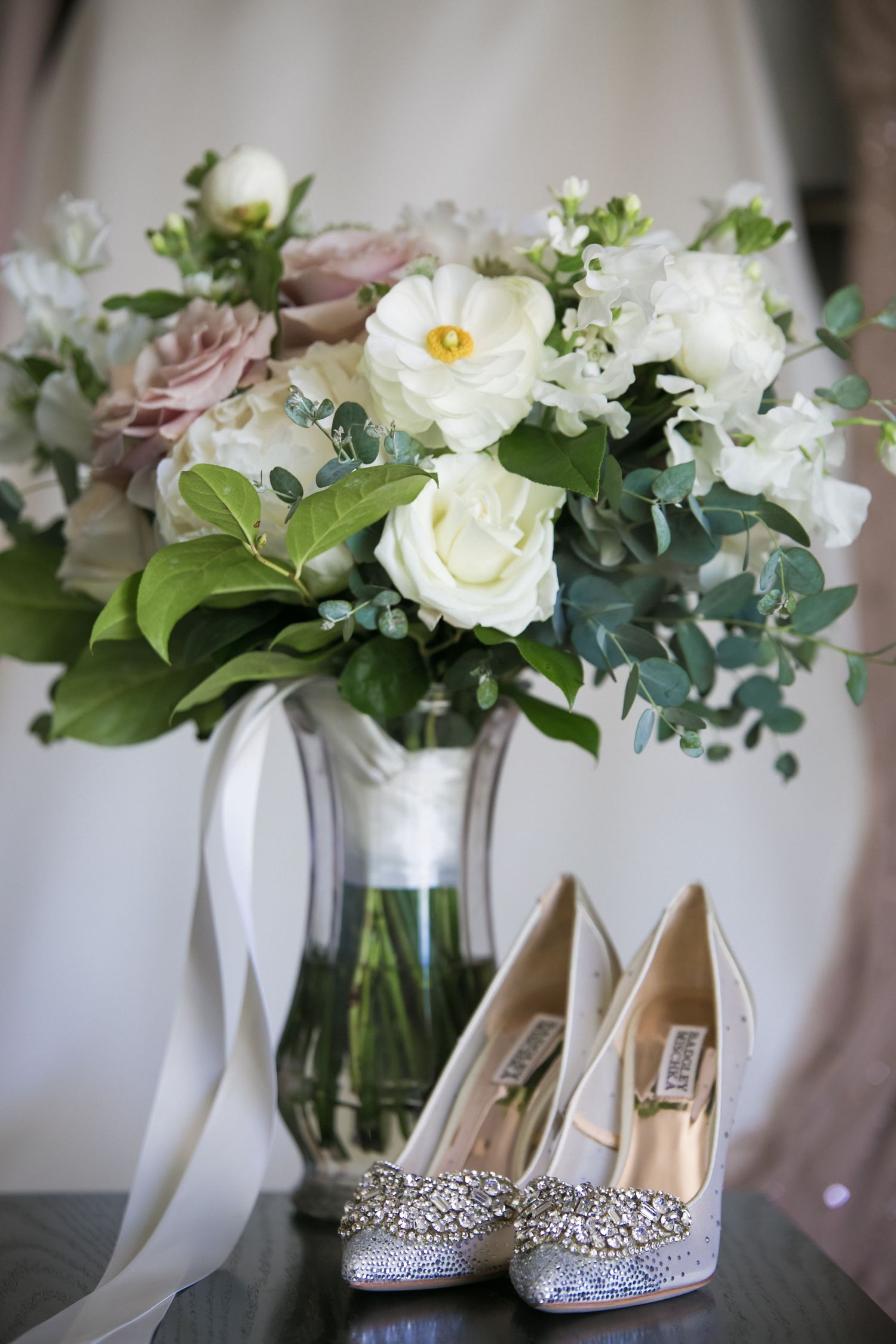 Bridal bouquet of white and blush flowers beside sparkling crystal-embellished wedding heels, Hilton Garden Inn Foxborough Patriot Place, MA