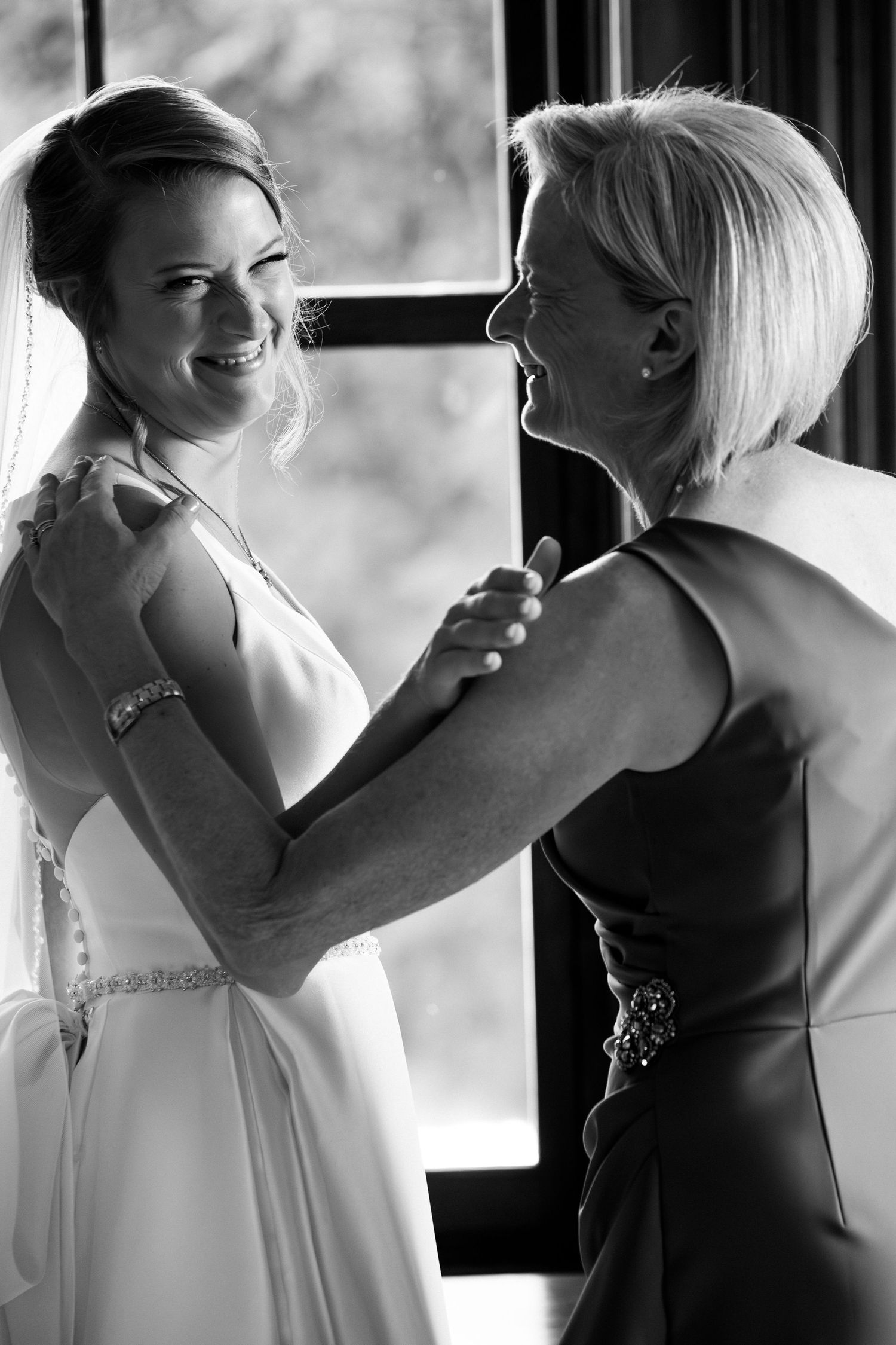 Black-and-white photo of a smiling bride and her mom sharing a joyful moment, Stevens Estate at Osgood Hill, North Andover, MA