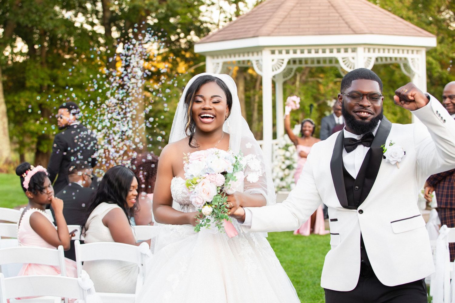 Joyful newlyweds leaving an outdoor gazebo ceremony amid bubbles, Independence Harbor, Assonet, MA