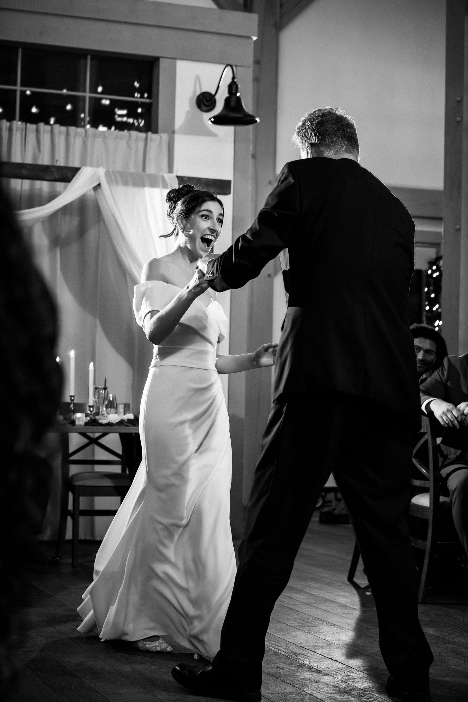 Black and white photo of excited bride in white gown dancing energetically with her father, Grove at Briar Barn Inn, Rowley, MA