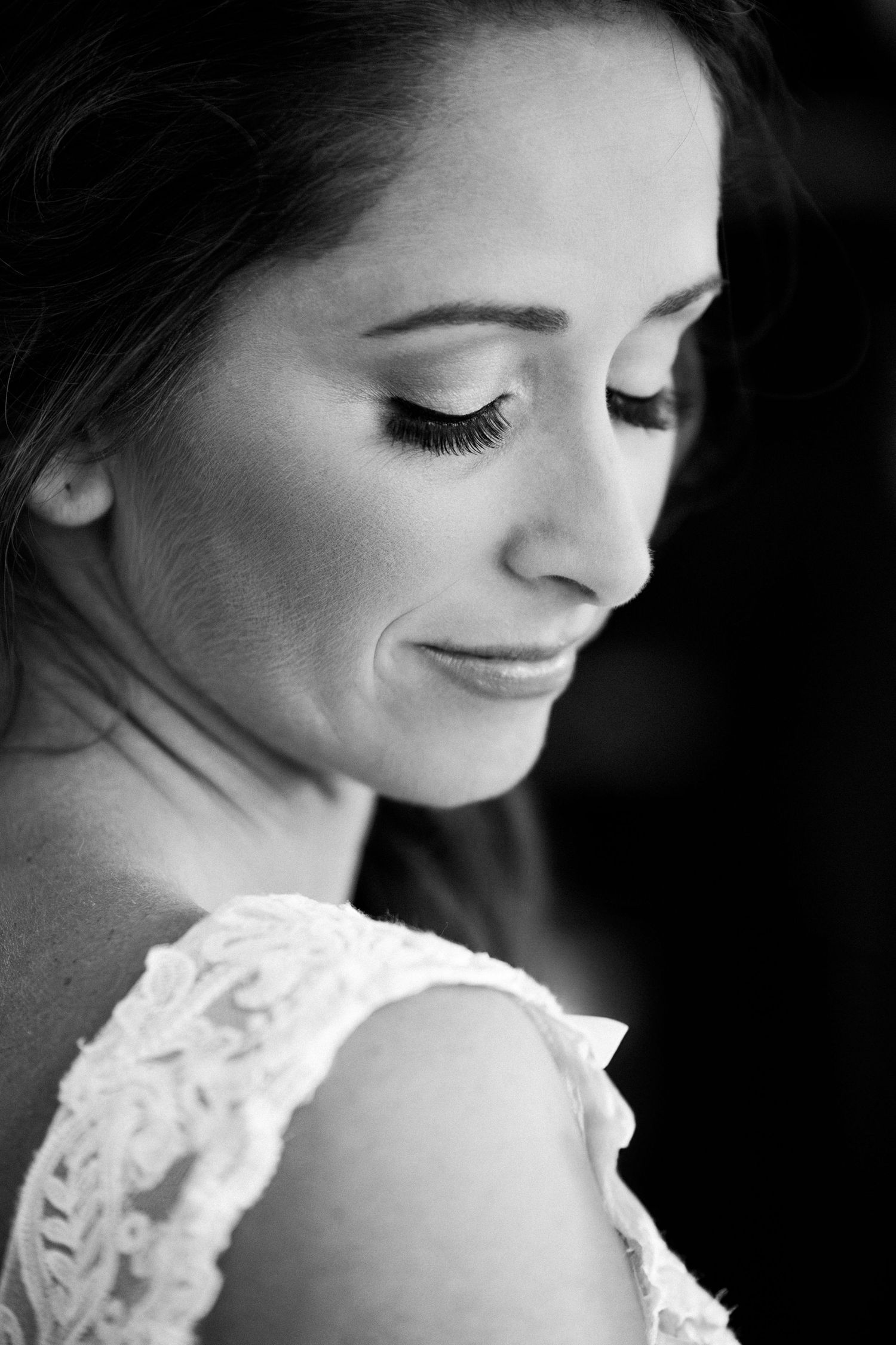 Elegant black and white close-up portrait of smiling bride in lace dress looking down, Barn at Bradstreet Farm, Rowley, MA