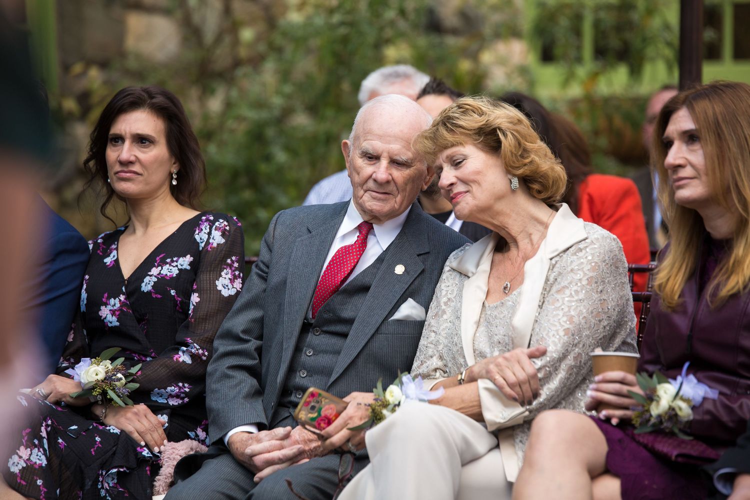 Wedding guests including an older couple share a tender moment seated at an outdoor ceremony, Willowdale Estate, Topsfield, MA