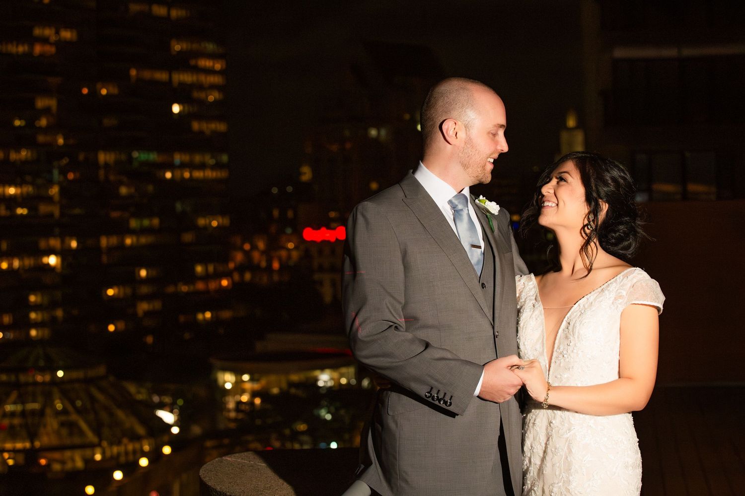 Bride and groom sharing a romantic moment on a rooftop with the Boston skyline at night, The Colonnade Hotel, Boston, MA