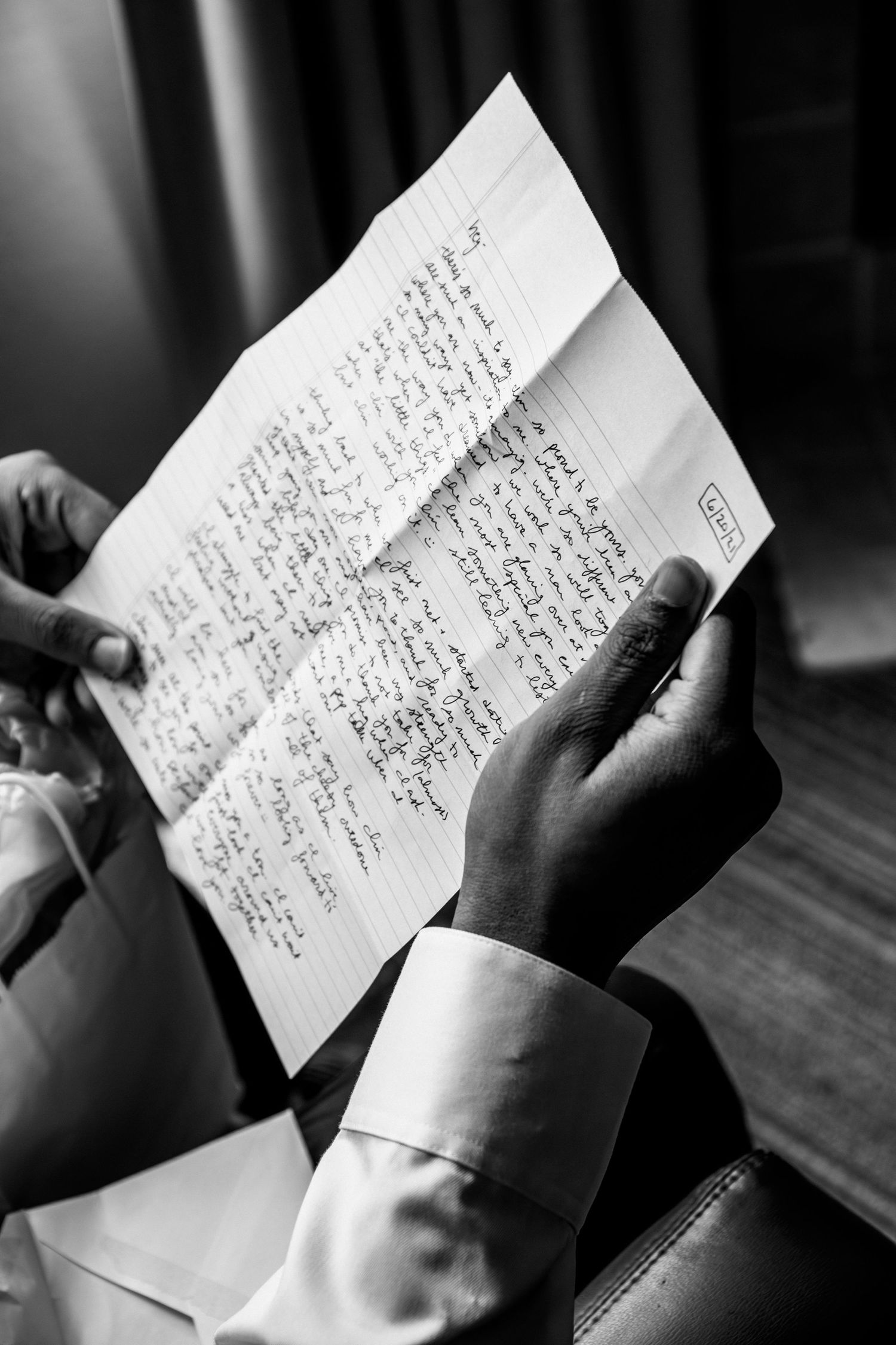 Groom reading handwritten letter in black and white wedding preparation moment, Groveland Fairways, Groveland, MA