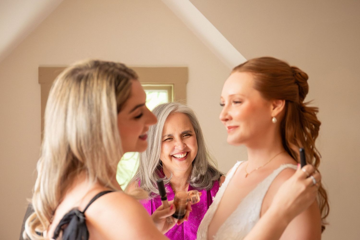 Two women help a red-haired bride prepare, adjusting her hair and dress before the wedding ceremony, Grove at Briar Barn Inn, Rowley, MA