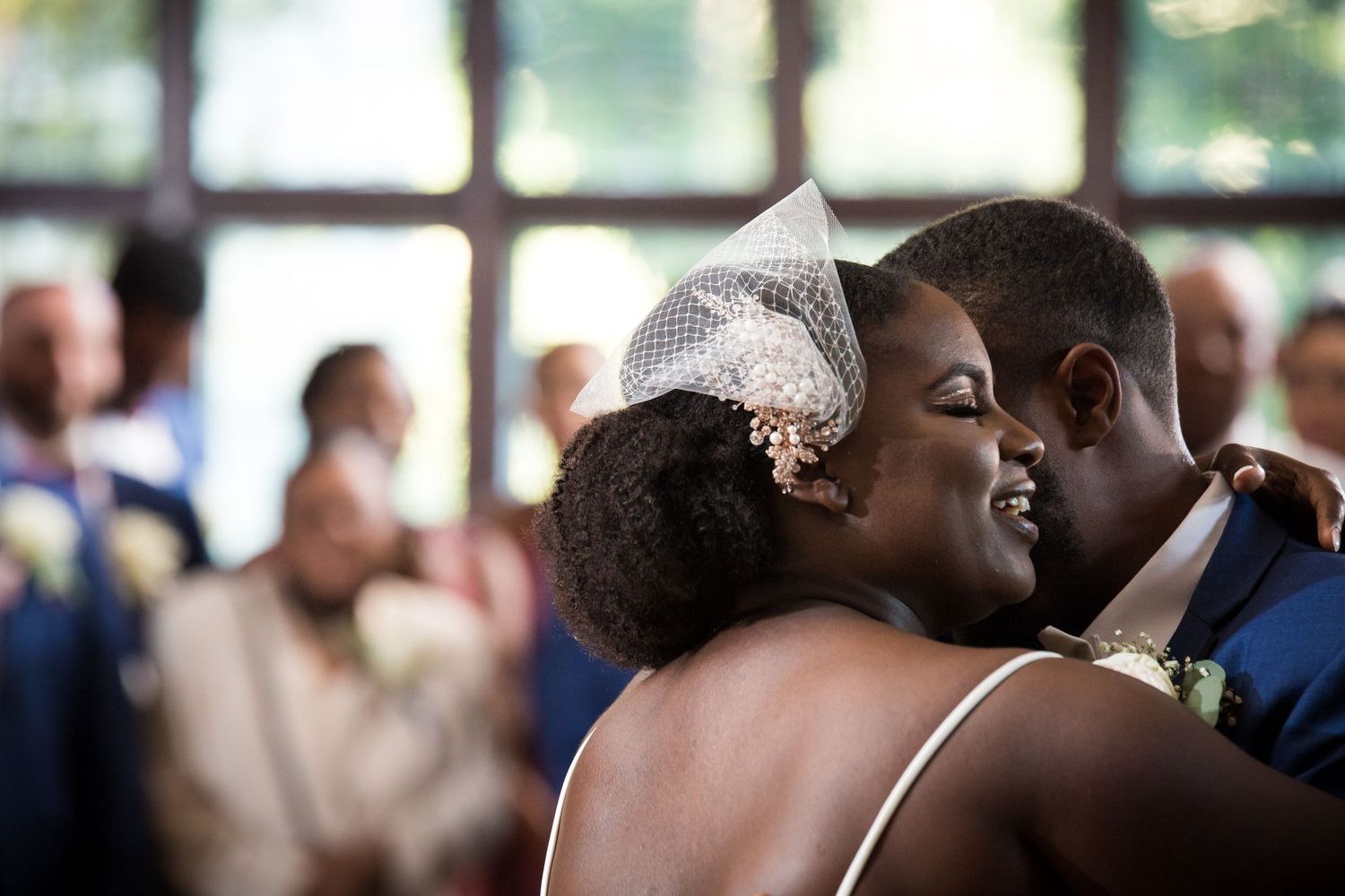 Joyful bride and groom share their first dance, smiling and embracing at a bright wedding reception, Xenia Helix Photography, Boston, MA