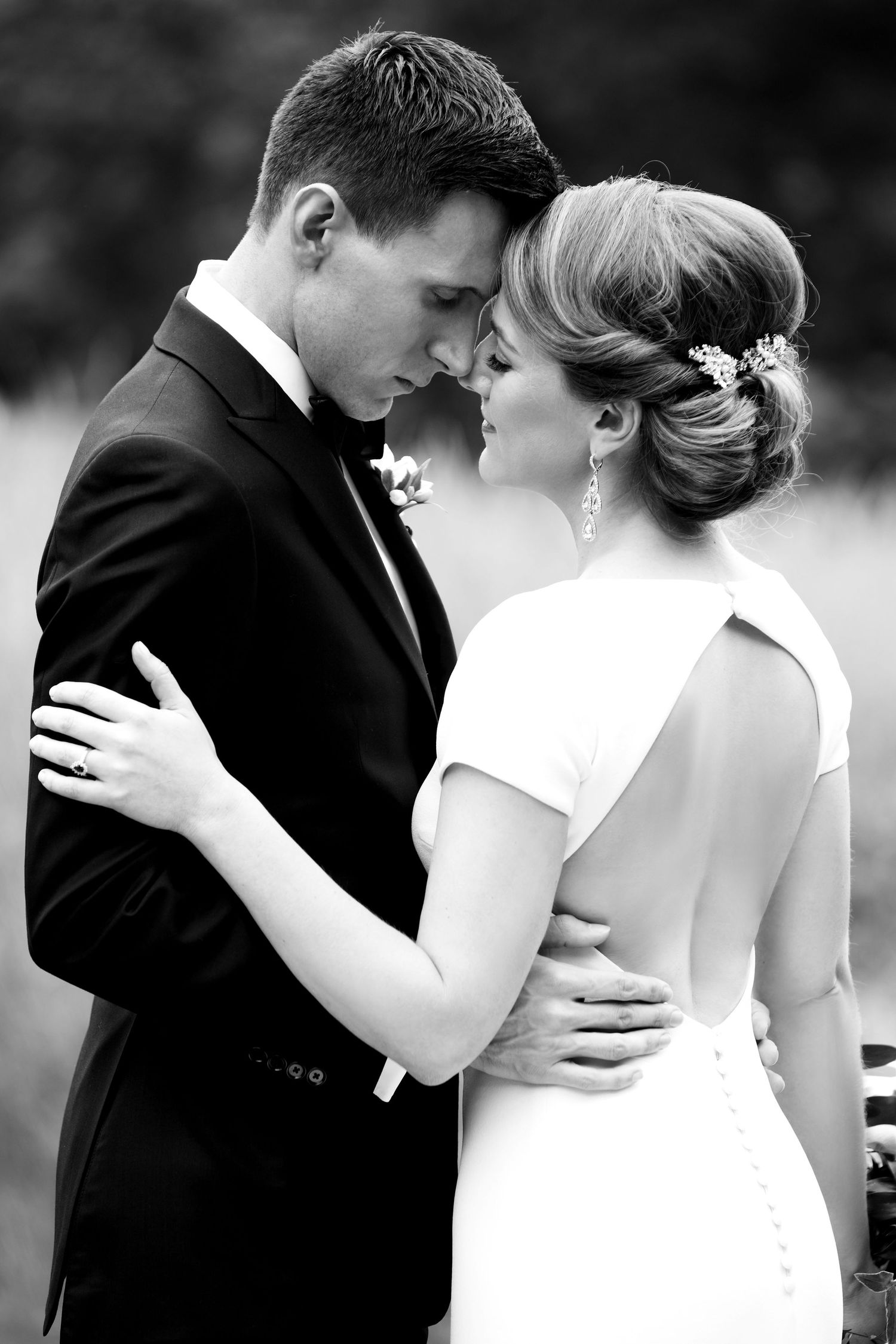Bride and groom share an intimate forehead-to-forehead embrace in classic black and white wedding portrait, Wellesley College, Wellesley, MA