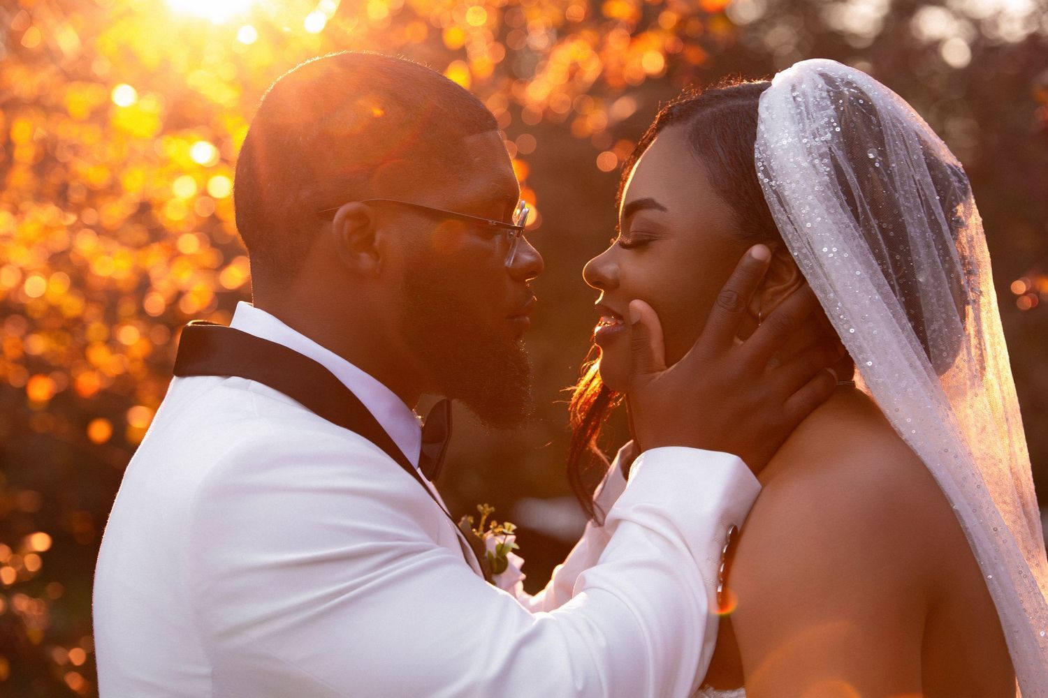 Bride and groom sharing an intimate moment at sunset, groom holding bride's face in warm golden light, Independence Harbor, Assonet, MA