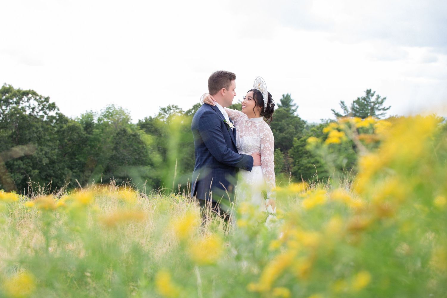 Bride and groom share a romantic moment in a sunny field of yellow wildflowers on their wedding day, Harrington Farm, Princeton, MA
