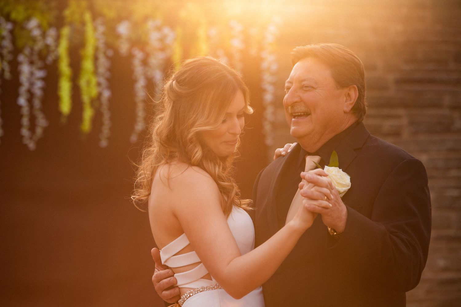 A bride and her father share a joyful father-daughter dance bathed in warm golden sunset light, Xenia Helix Photography, Boston, MA
