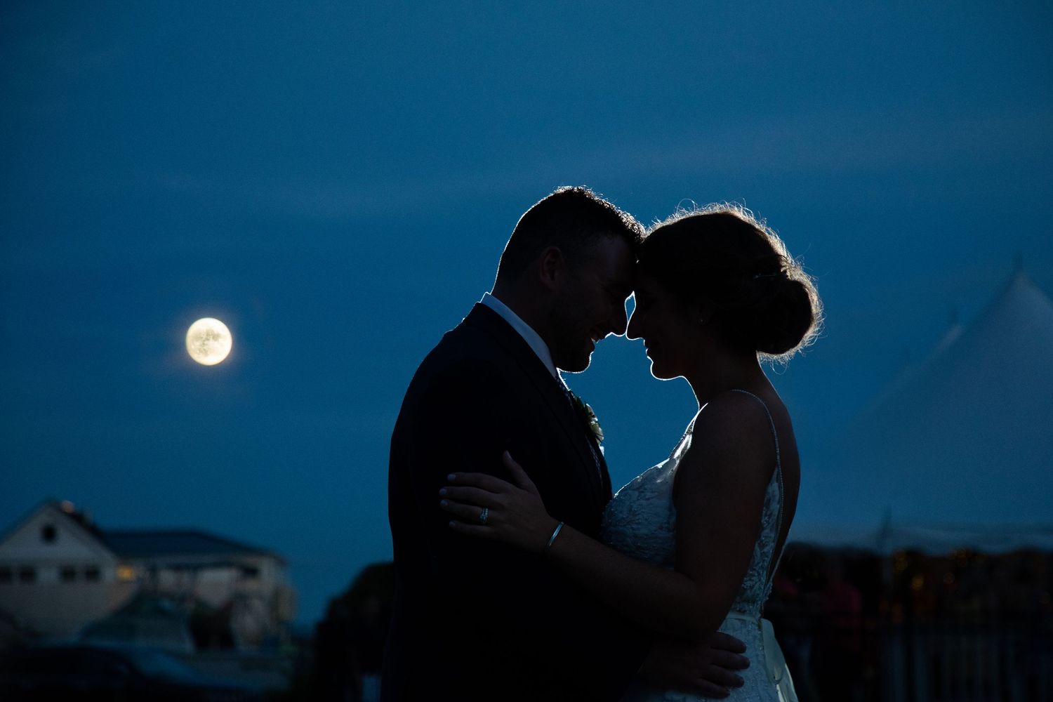 Silhouette of bride and groom embracing under a full moon at twilight, East Bay Grille, Plymouth, MA