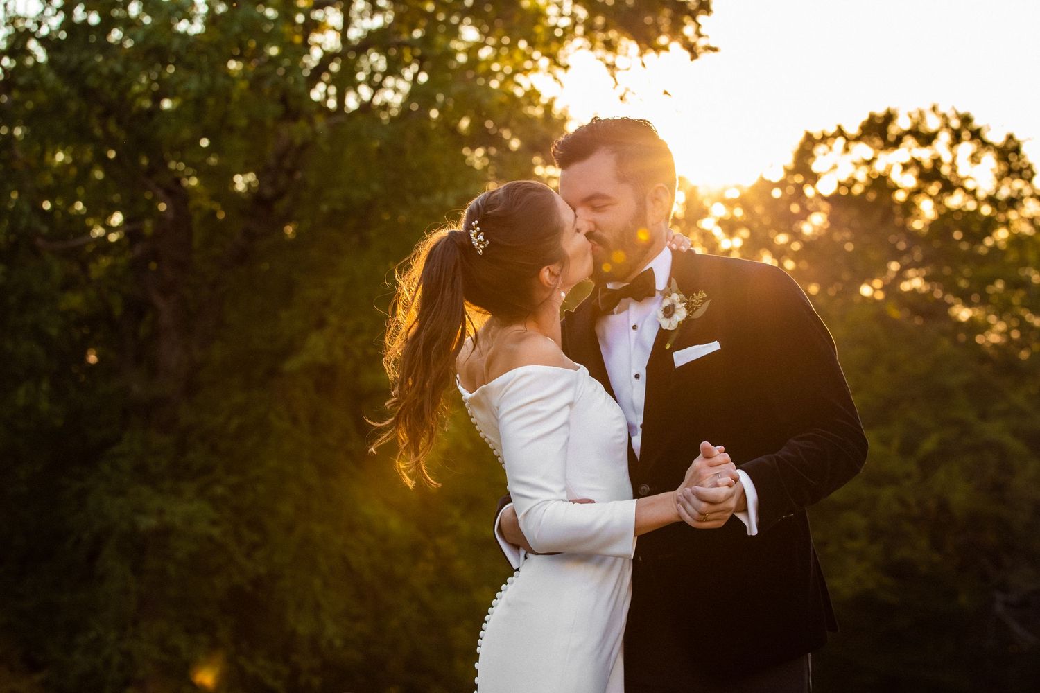 Bride and groom sharing a romantic dance kiss bathed in warm golden sunset light outdoors, Xenia Helix Photography, Boston, MA