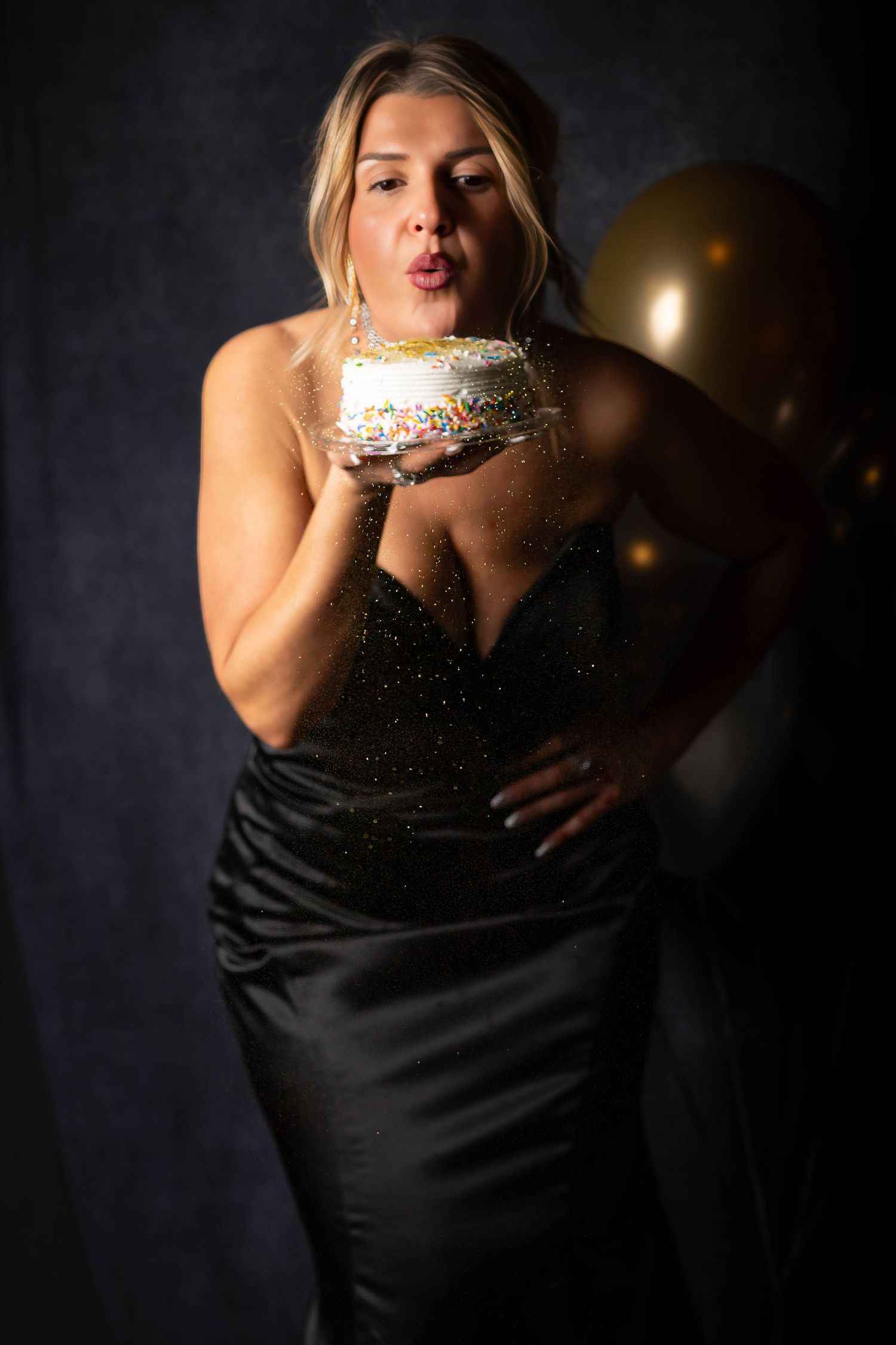 A dramatic photo series showing someone in a black evening gown with sparkly details against a dark background.